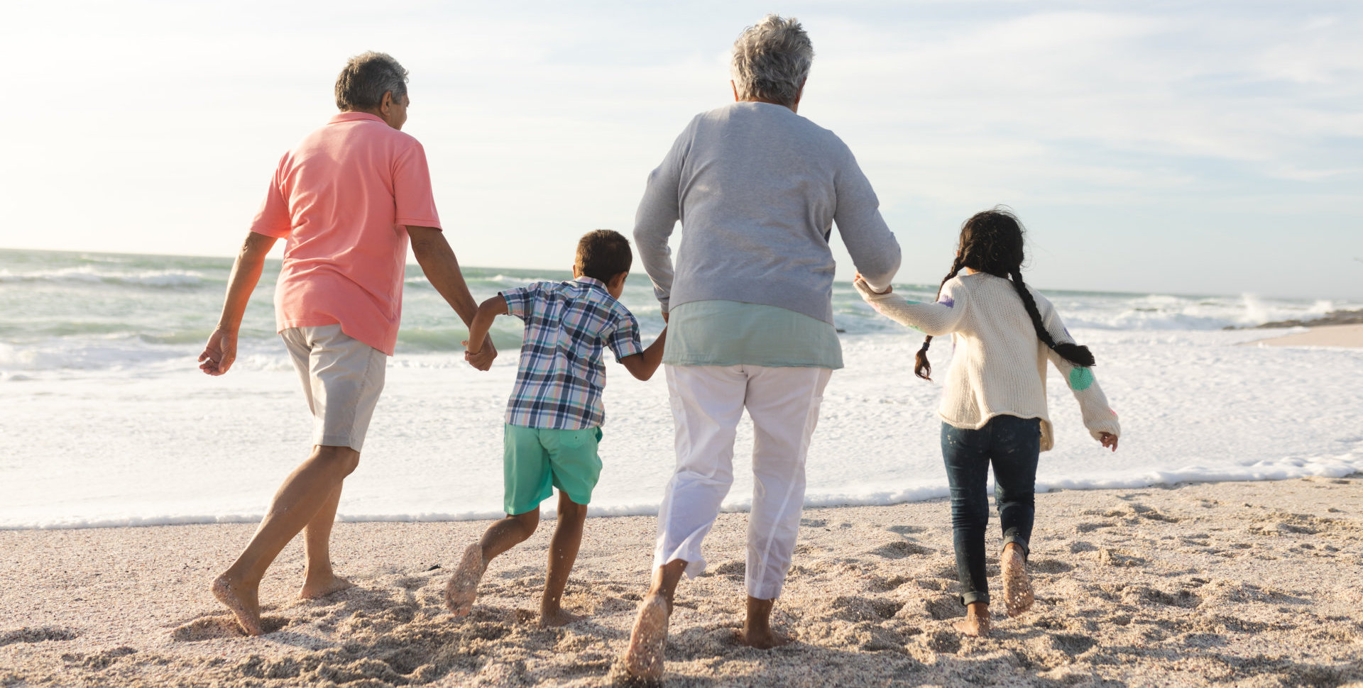 elderlies and grandchildren walking on the beach
